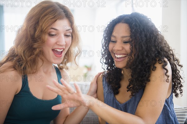 Woman admiring engagement ring of friend