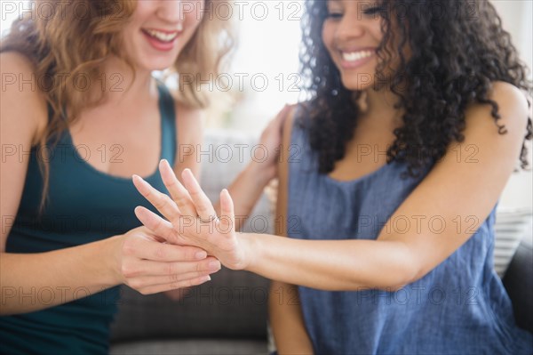 Woman admiring engagement ring of friend