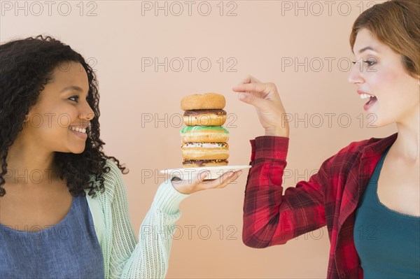 Women enjoying stack of donuts