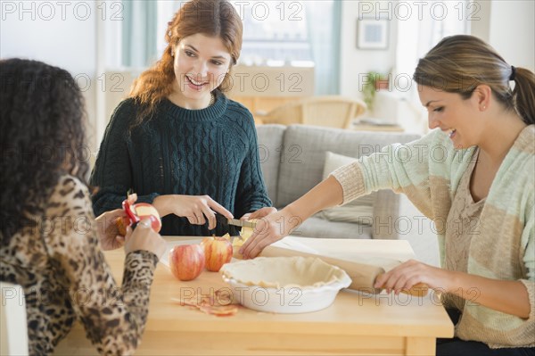Women baking pie in kitchen