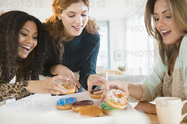 Women eating donuts at breakfast