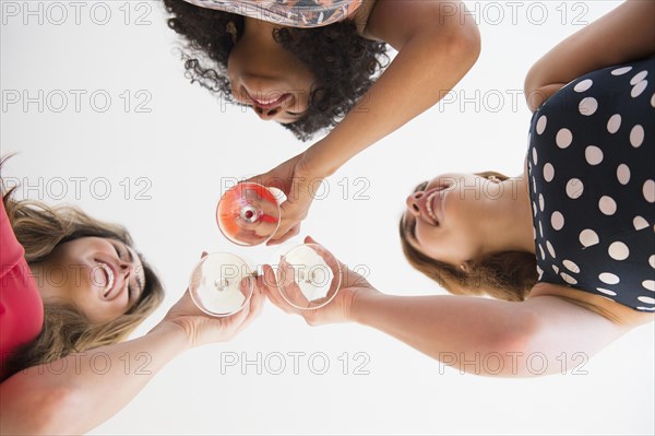 Low angle view of women toasting with cocktails