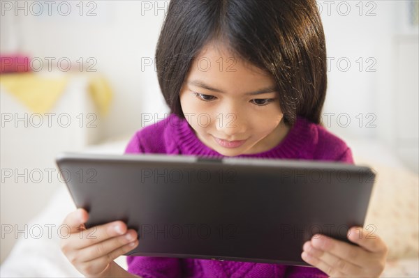 Smiling Vietnamese girl using digital tablet