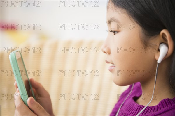 Close up of Vietnamese girl listening to mp3 player