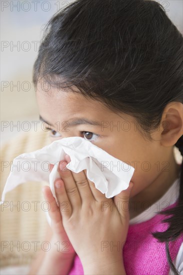 Close up of Vietnamese girl blowing her nose