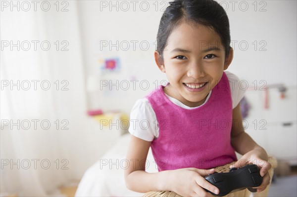 Close up of Vietnamese girl playing video game