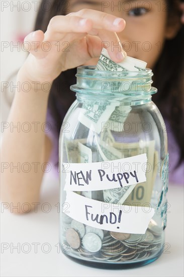 Vietnamese girl saving money in new puppy fund