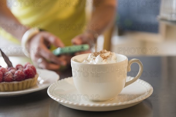 Caucasian woman using cell phone at cafe