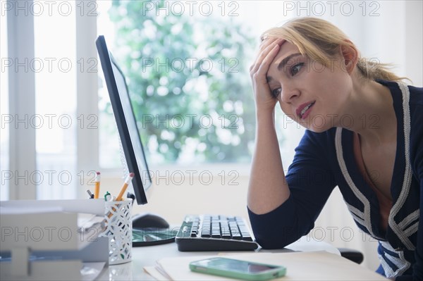 Frustrated Caucasian businesswoman using computer