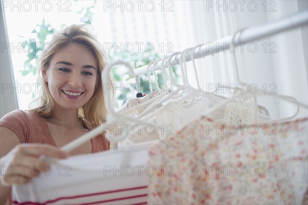 Smiling Caucasian woman shopping in clothing store