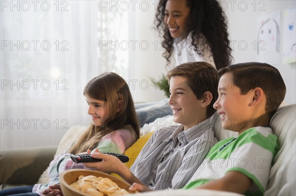 Children watching television on sofa