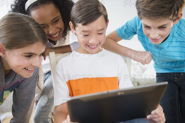 Smiling children using digital tablet
