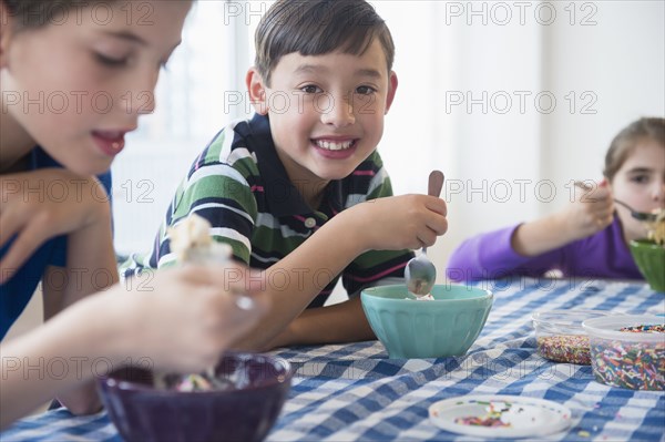 Close up of smiling children eating ice cream sundaes