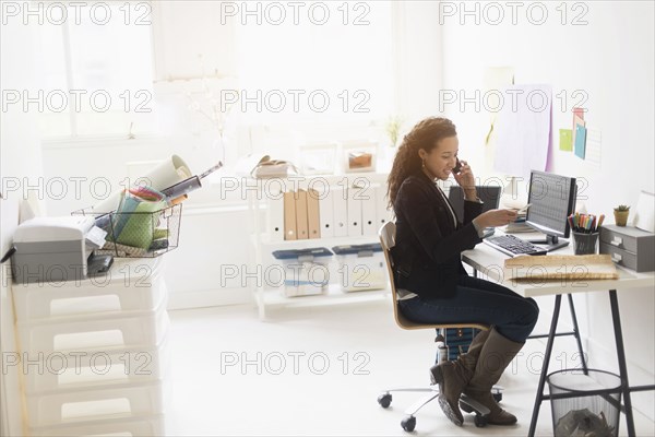 Mixed race businesswoman working at desk