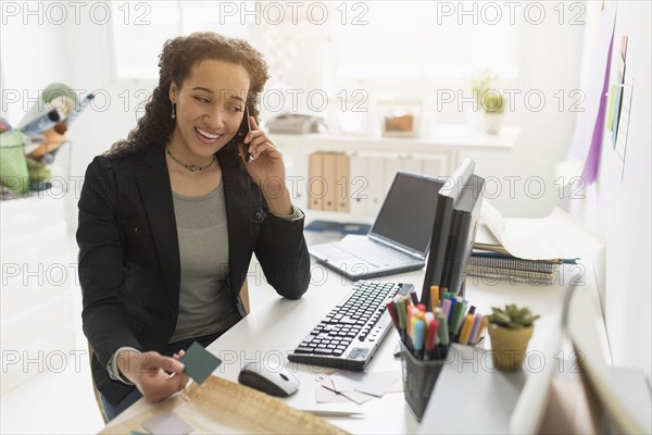 Mixed race businesswoman working at desk