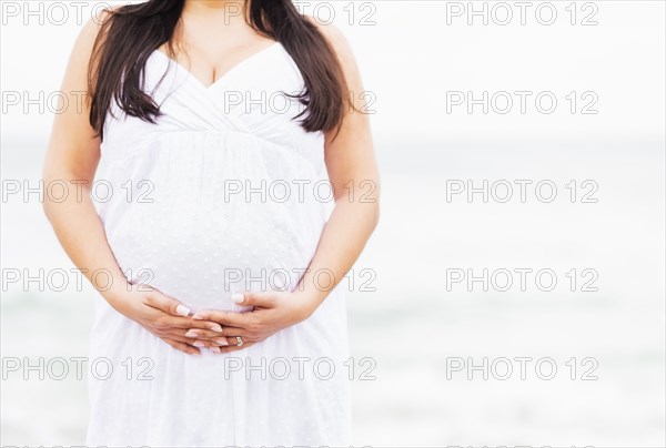 Close up of mixed race woman holding pregnant belly