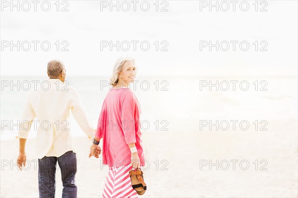 Older couple walking on beach