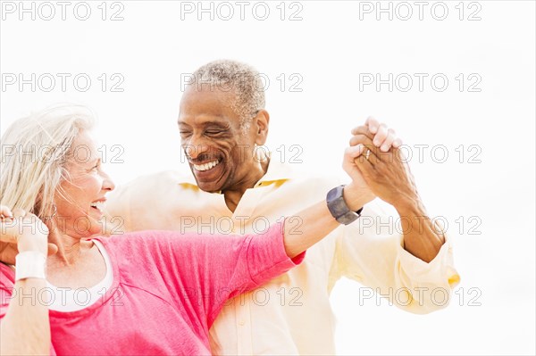 Older couple dancing on beach