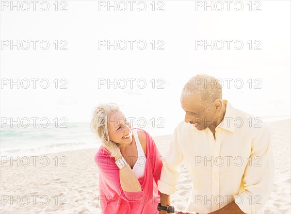 Older couple walking on beach