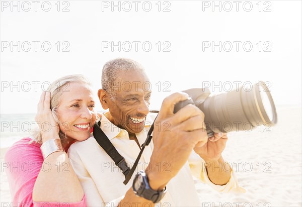 Older couple photographing on beach