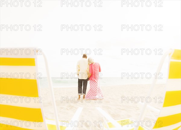 Older couple hugging on beach