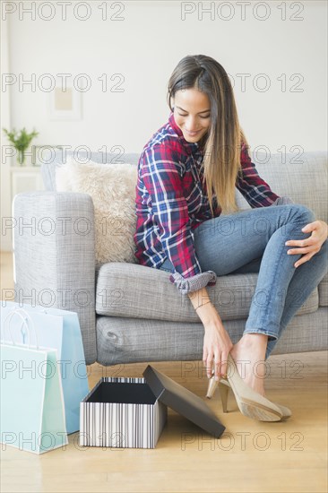 Caucasian woman trying on high heels on sofa