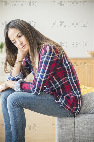 Sad Caucasian woman sitting on sofa