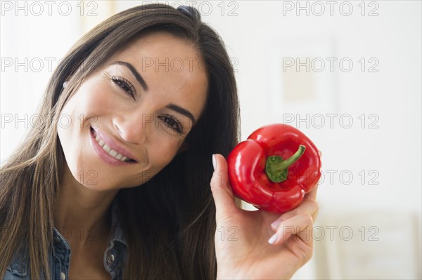 Smiling Caucasian woman holding red pepper