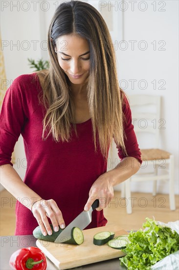 Caucasian woman slicing vegetables for salad