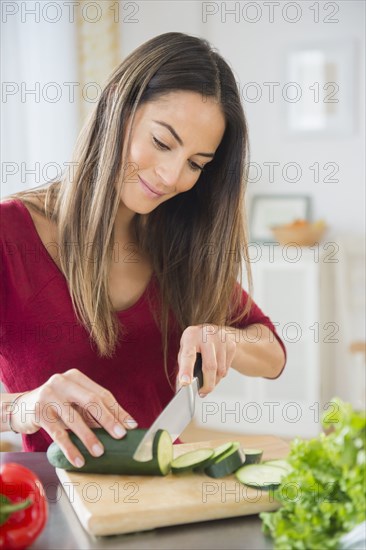 Caucasian woman slicing vegetables for salad