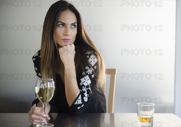 Lonely Caucasian woman drinking white wine in bar