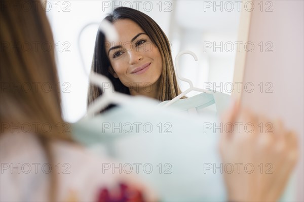 Caucasian woman admiring shirt in mirror