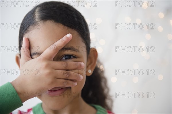 Close up of mixed race girl peeking between fingers