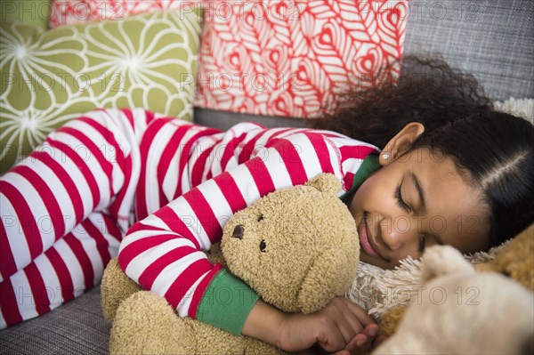 Mixed race girl sleeping on sofa