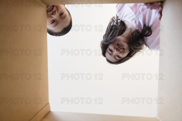 Low angle view of Asian brother and sister opening box