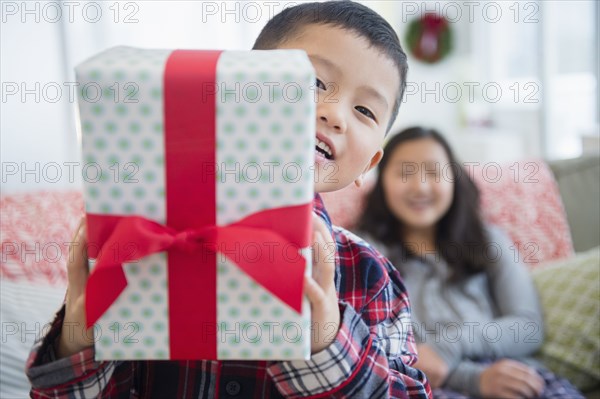 Asian brother with sister holding Christmas gift