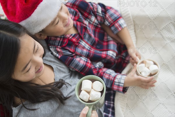 Asian brother and sister drinking hot cocoa at Christmas