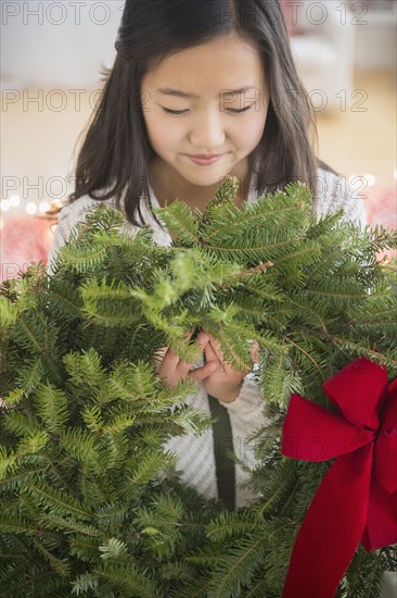 Asian girl carrying Christmas wreath