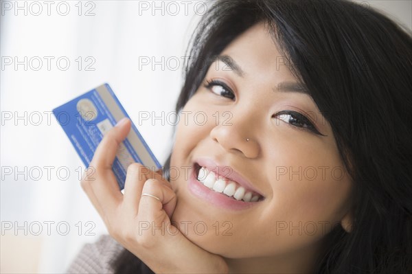 Smiling Pacific Islander woman holding credit card
