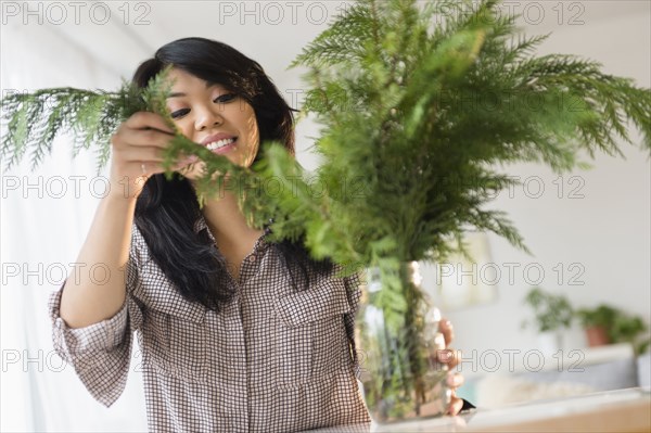 Pacific Islander arranging plants in jar