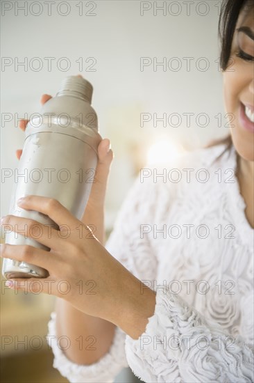 Pacific Islander woman shaking cocktail shaker