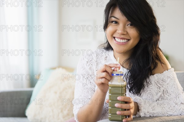 Pacific Islander woman drinking green juice