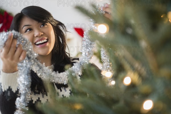 Pacific Islander woman decorating Christmas tree