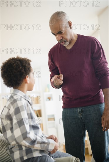 Mixed race grandfather scolding grandson