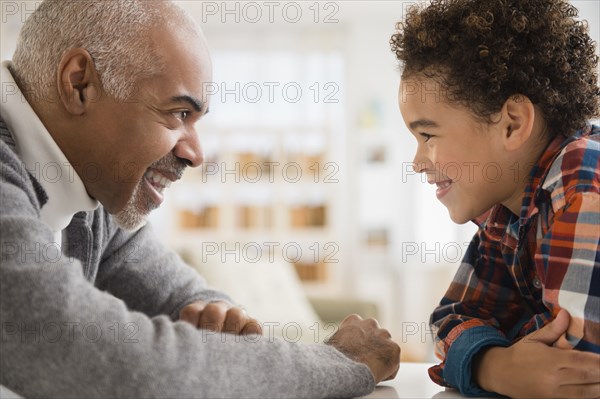 Mixed race grandfather and grandson having staring contest