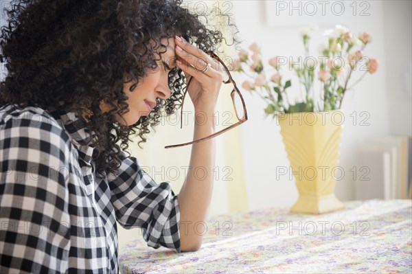 Anxious mixed race woman sitting at table