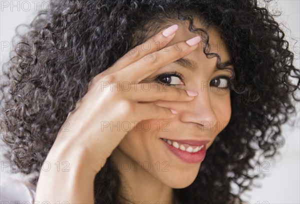 Mixed race woman with curly hair smiling