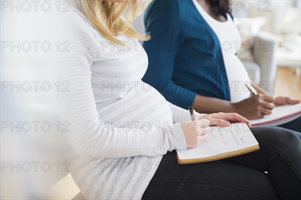 Pregnant women taking notes in class