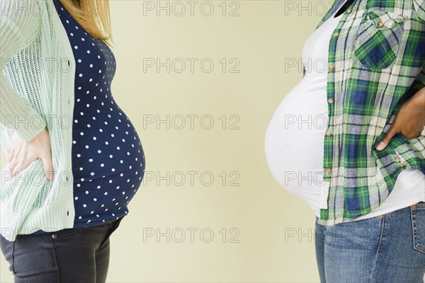 Pregnant women displaying profile of midsections