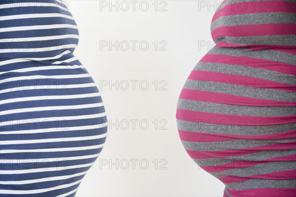 Close up midsection profiles of stomachs of pregnant women